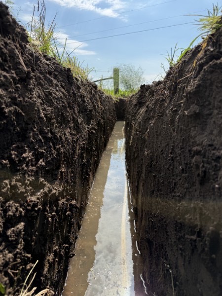Clean, deep sewer trench dug across a property