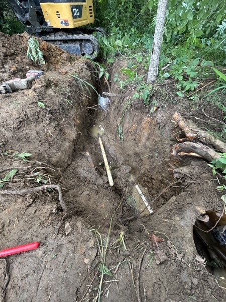 Excavating a sewer line trench with a mini-excavator